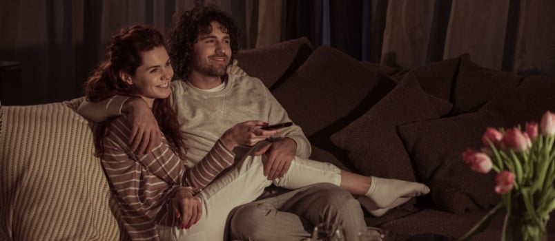Couple watching TV sitting on couch