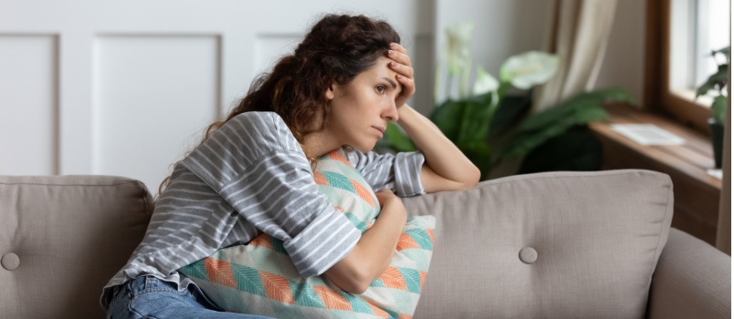 Stressed woman sitting on couch