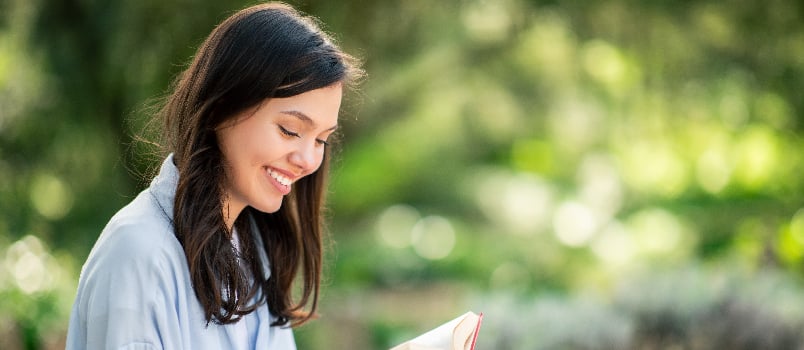 Girl reading a book while sitting in the park