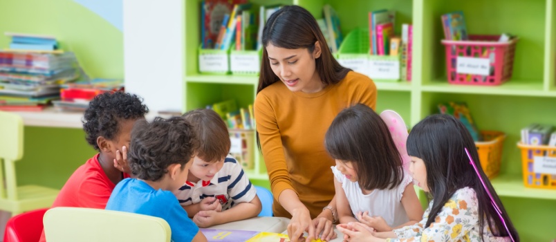 Female teacher teaching mixed race kids