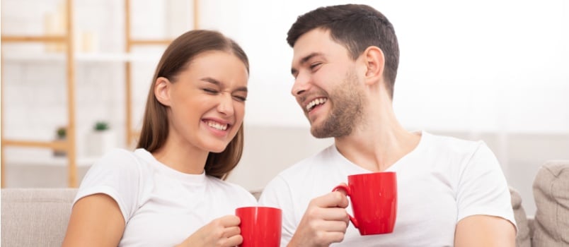Joyful couple enjoying morning coffee