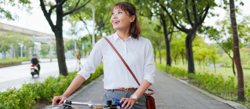 Happy businesswoman commute her bicycle