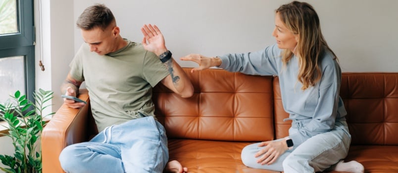 Man using smartphone ignoring wife
