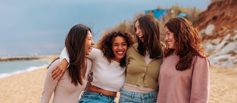 Four diverse friends enjoying near beach