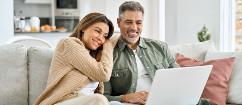 Happy middle aged couple using laptop