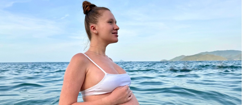 Happy pregnant young woman swimming