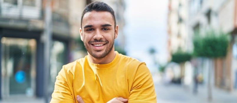 Young man standing arm closed