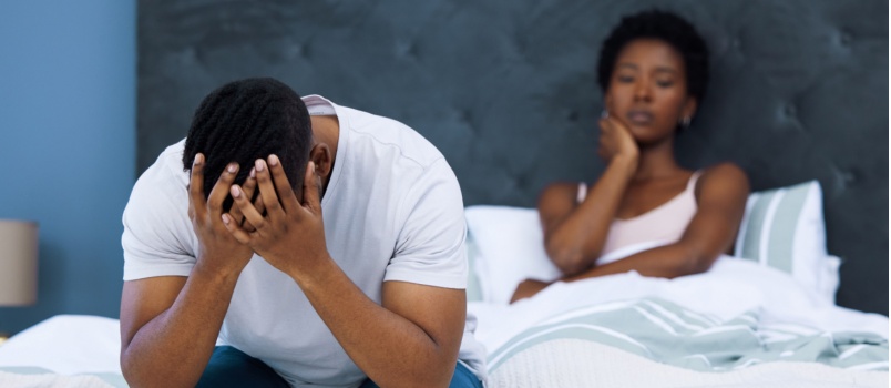 Stressed couple sitting on bed