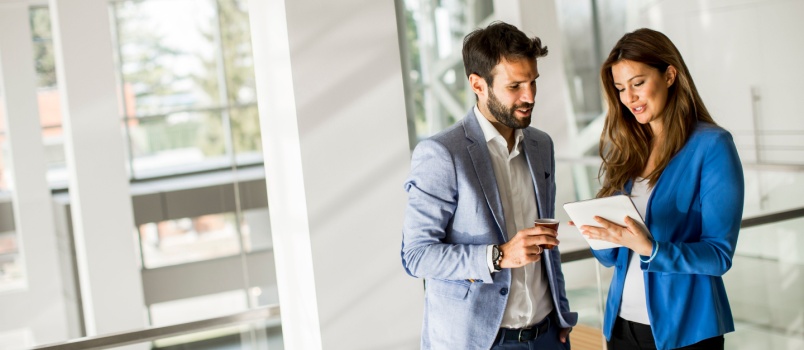Business people standing talking in kitchen
