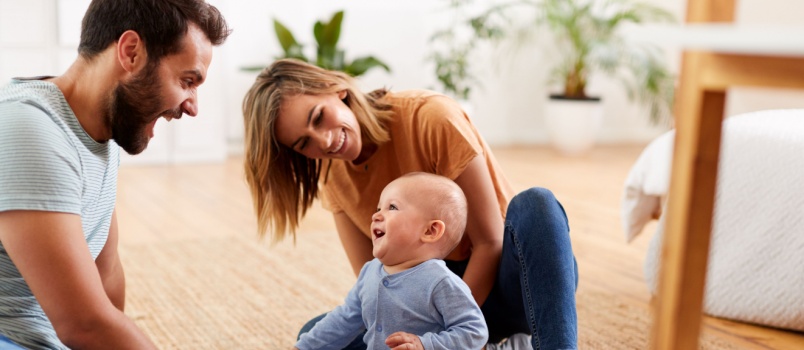 Parents sitting on floor playing with kid