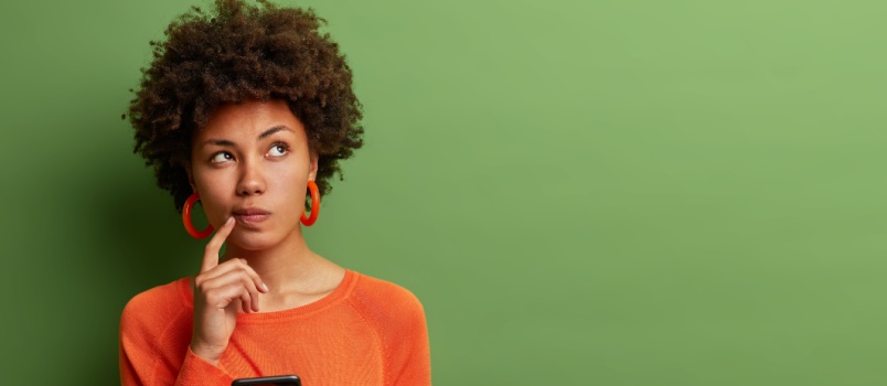 Woman thinking while using phone