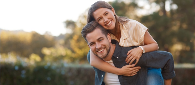 Man pigyback her woman