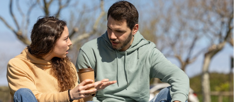 Couple sitting in park talking to each other