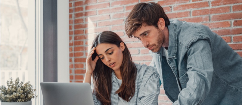 Young tensed couple using laptop