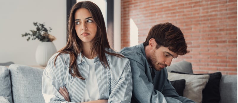 Depressed couple sitting on couch