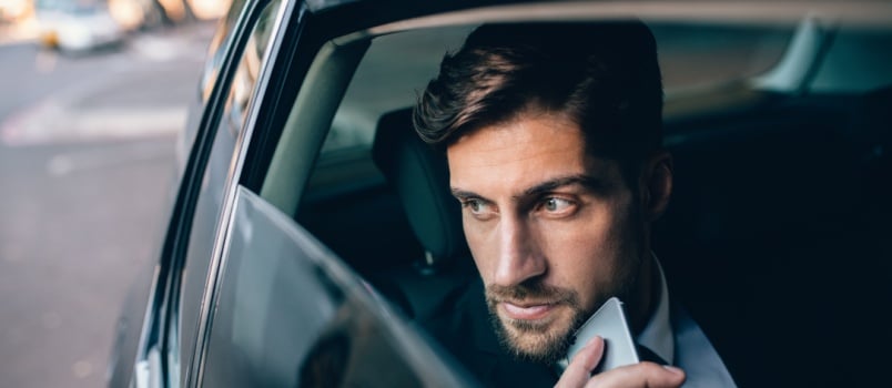 Young man looking away while siting in car