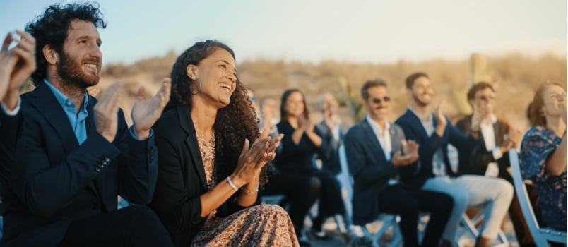 Guest sitting outdoor venue clapping