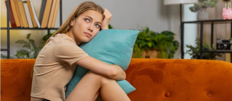 Sad a lonely woman laying on couch