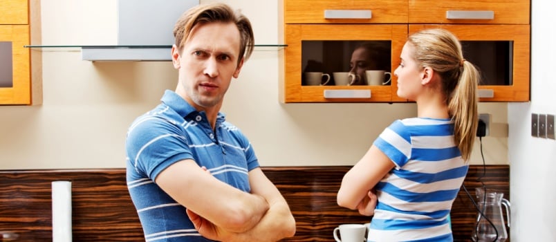 quarreling couple standing in kitchen not talking to each other