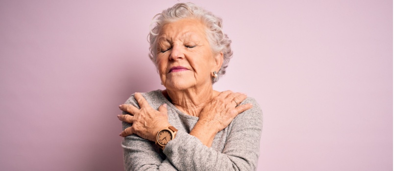 Old woman hugging herself