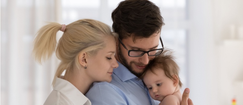 Young married couple holding baby