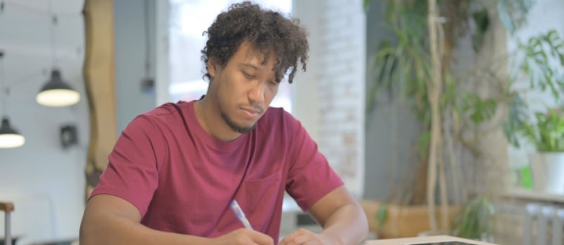 African man writing letter