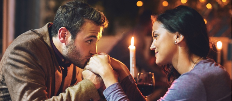 Man kissing woman hand