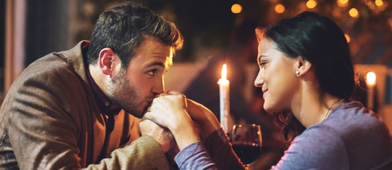 Man kissing woman hand