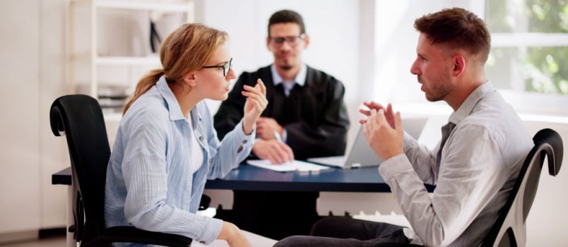 Young couple arguing infront of male judge