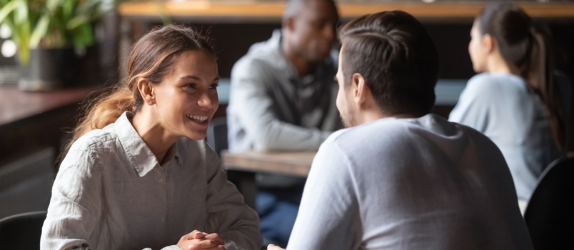 Happy couple chatting sitting in cafe