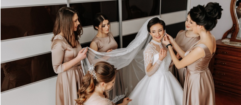Bridesmaids helping bride