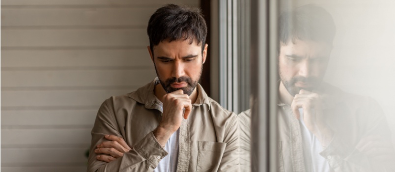 Un homme appuyé contre la fenêtre