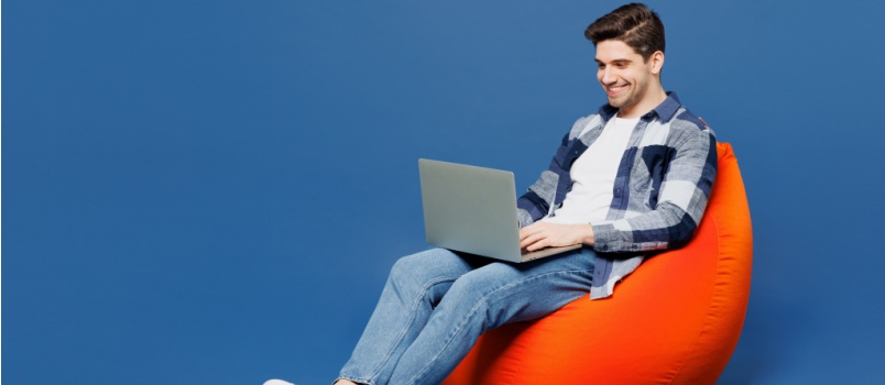 Man sitting on bean bag working on laptop