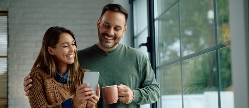 Happy couple using mobile phone