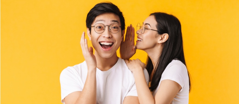 Woman whispering in man's ears