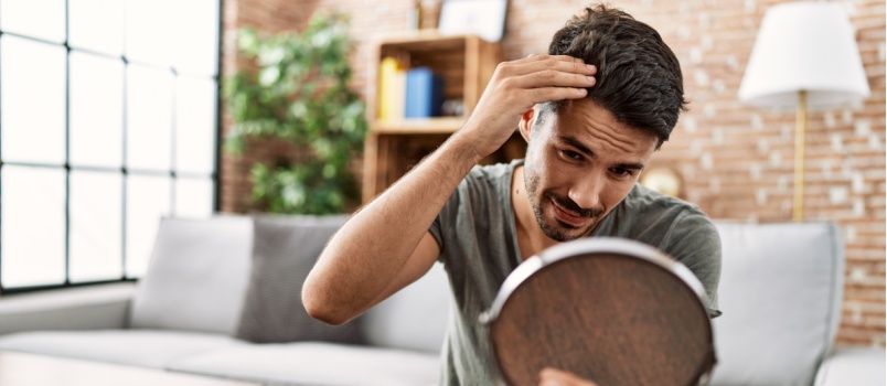 Man looking at his hairs in mirror