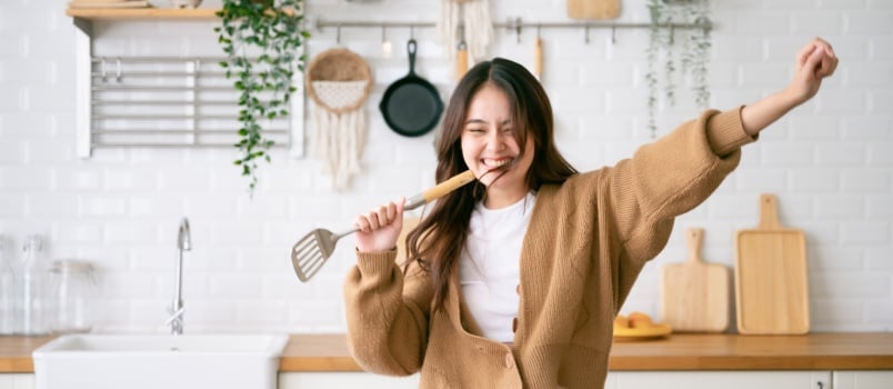 Young woman dancing in kitchen room