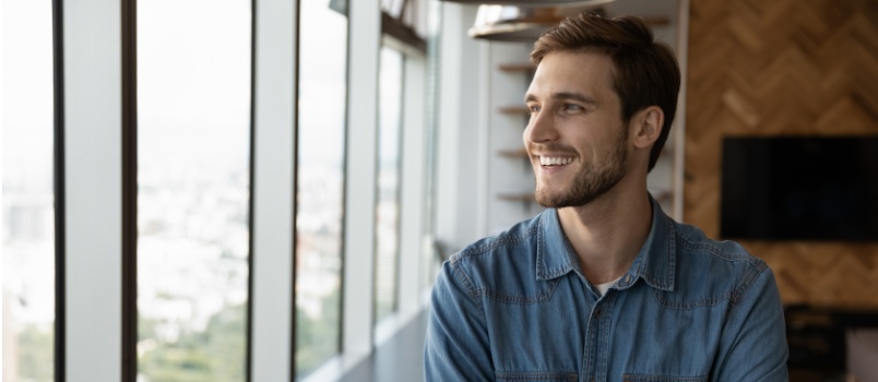 Happy man looking outside of window