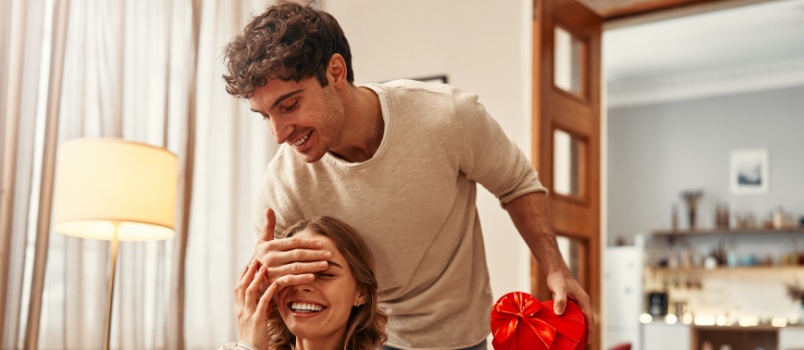 Man surprising woman with gift
