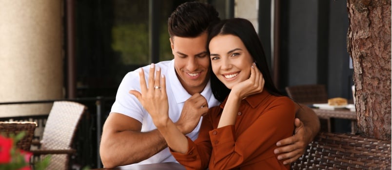 Beautiful couple showing engagement ring