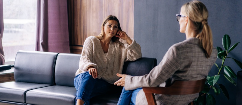 Young woman listening to psychologist
