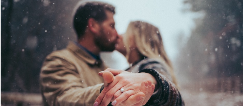 Couple kissing showing rings