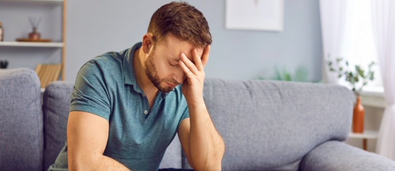 Sad man sitting alone on couch
