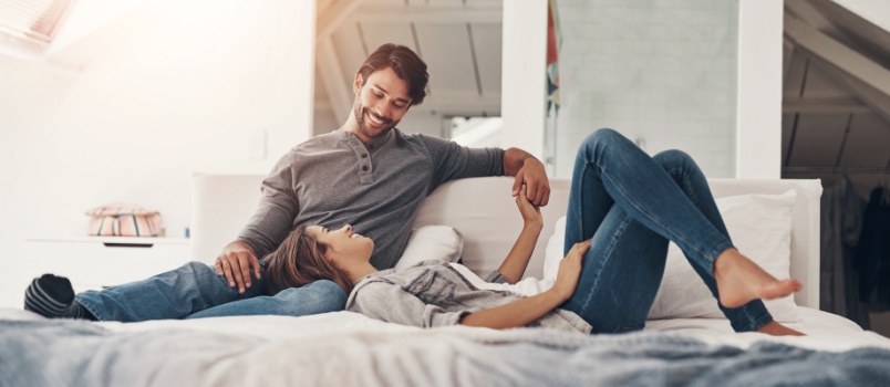 Relaxed couple holding hands in bed