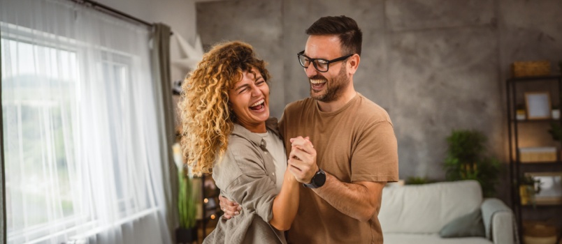 Happy couple dancing at home