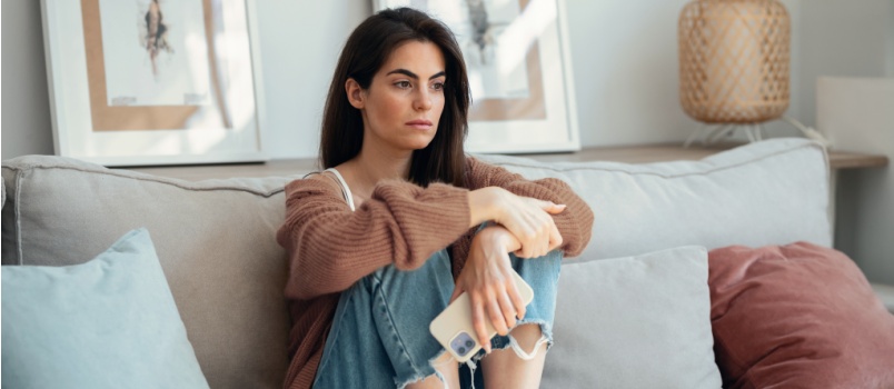 Sad young woman sitting alone