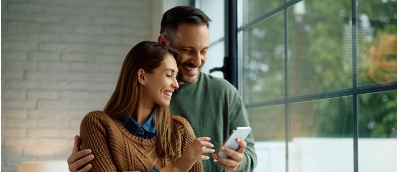Happy couple having fun using smartphone