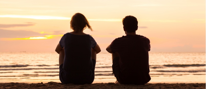 Friends sitting on beach together