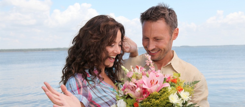 Man surprising woman with flowers