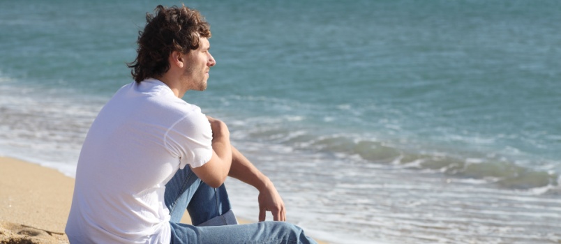Man sitting beside the beach